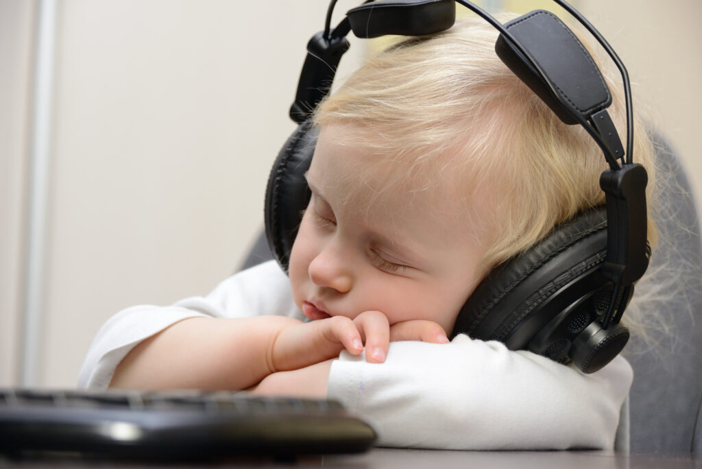 bambino che dorme mentre ascolta musica dalle cuffie